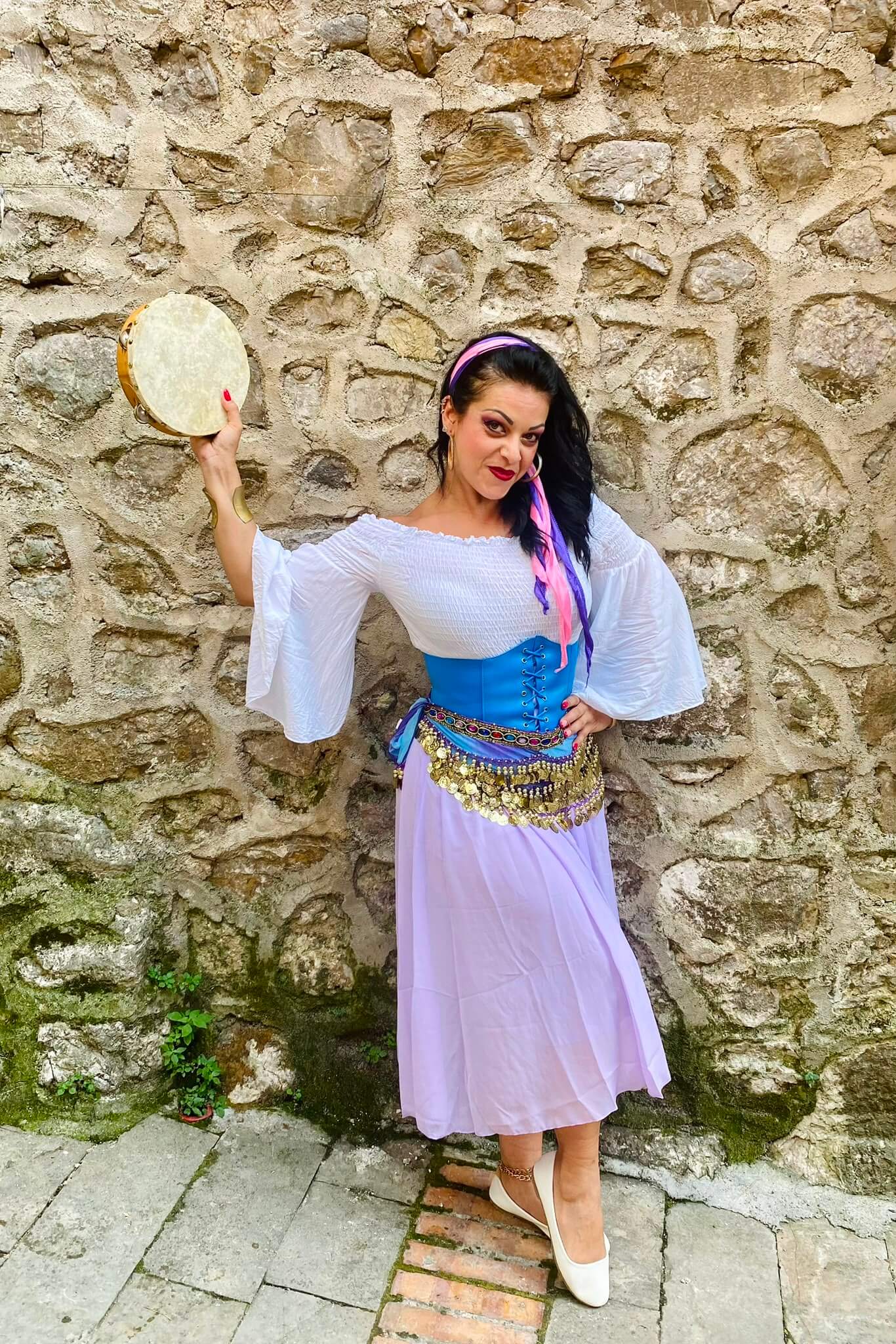 Personaggio con abito lungo al tramonto nel cortile del castello